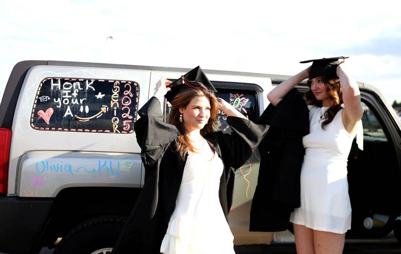 St. Charles East graduates Olivia Hill (left) and Kylie Parham adjust their caps before the school’s 2025 commencement ceremony on Thursday, May 22, 2025 at Northern Illinois University in DeKalb.