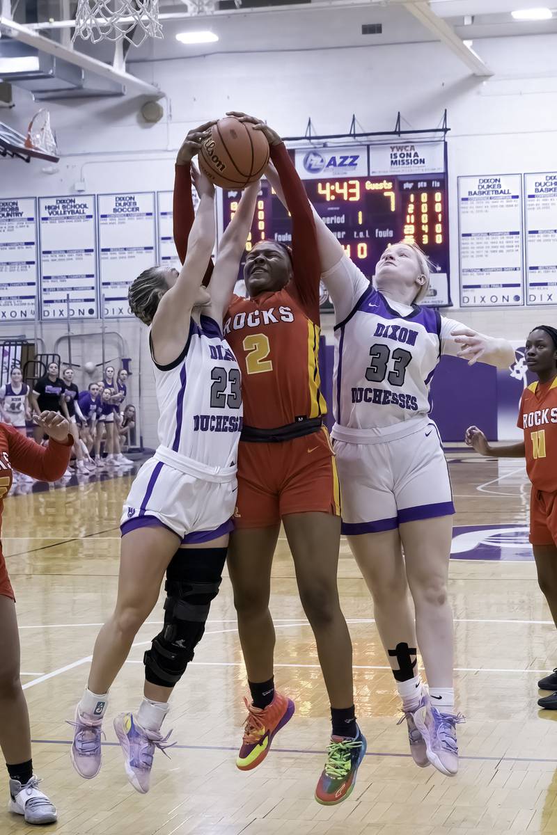 Dixon's Hannah Steinmeyer (23) and Jessie Pitman (33) battle for a rebound with Rock Island's Ka'Zaria Bell during their Class 3A Dixon Regional semifinal Tuesday, Feb. 14, 2023 at Lancaster Gym.