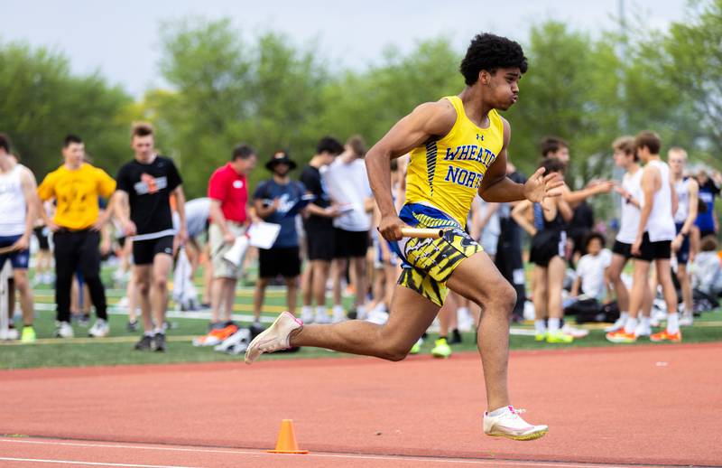 Anthony Bach races to his teammate during the varsity 4x100 race during the Dukane Conference Boys Track and Field Meet hosted by Lake Park High School in Roselle on Friday, May 16, 2025.