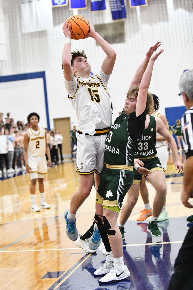 Joliet Catholic Academy's Brady Tunkel shoots under pressure from Bishop McNamara's Trey Provost during the Fightin' Irish's 79-67 victory over the Hilltoppers in the IHSA Class 2A Peotone Sectional semifinal on March 4, 2025.
