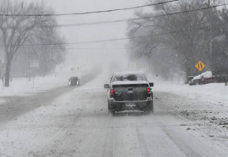 Vehicles travel on Illinois 64 near Oregon on Saturday, Nov. 29, 2025 as several inches of snow fall across the region. Winds were expected to cause drifting throughout the evening making driving more difficult across the region.