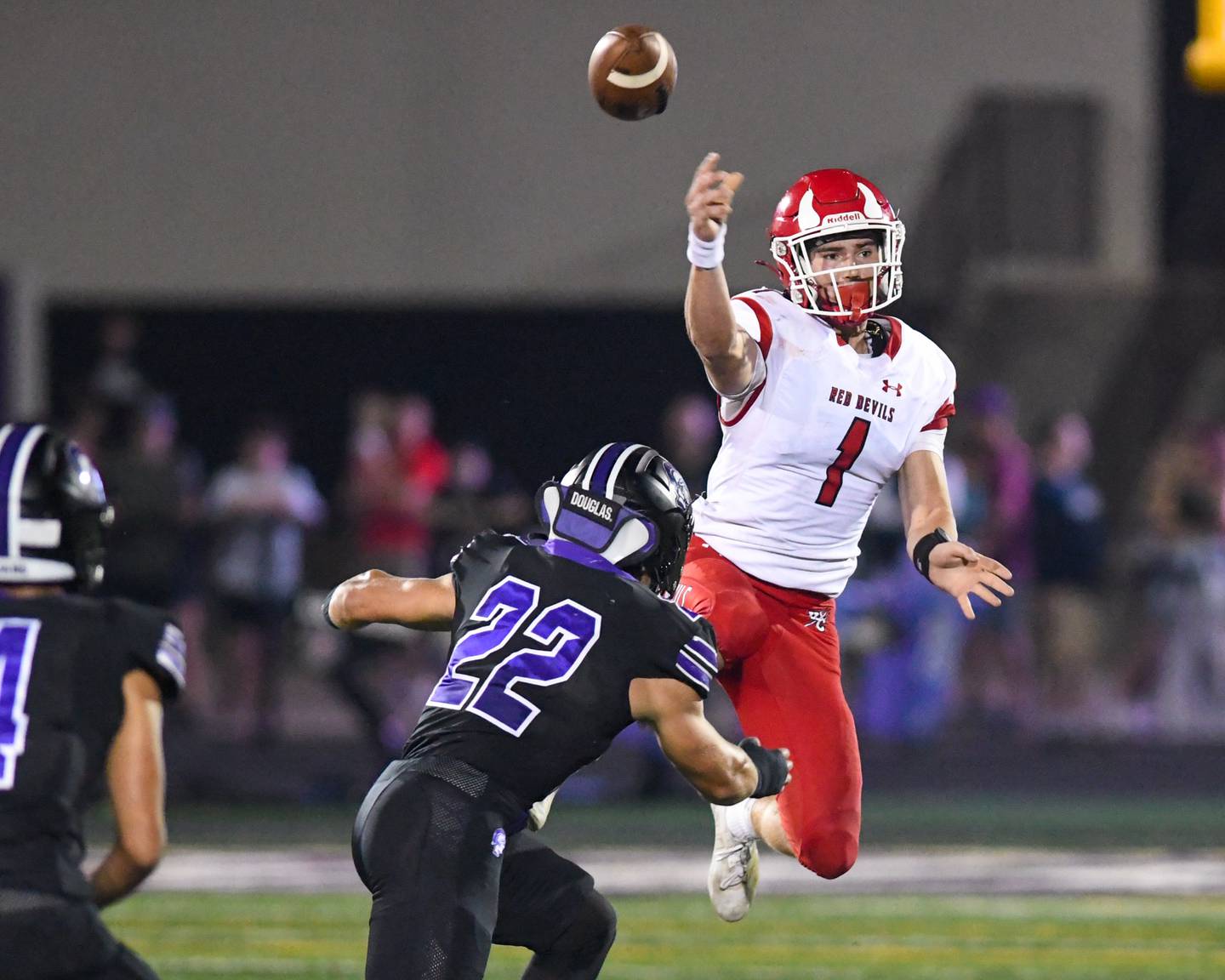 Hinsdale Central's Riley Contreras (1) throws the ball on the fly while being defended by Downers Grove North's Joe LaSota (22) during the game on Friday Sept. 12, 2025, held at Downers Grove North High School.