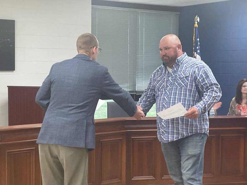 New Utica village trustee Pete Pawlak (right) shakes hands with Mayor David Stewart after taking the oath of office Tuesday, July 11, 2023, at Utica Village Hall. Pawlak was appointed to the seat vacated by his late mother, Mary.