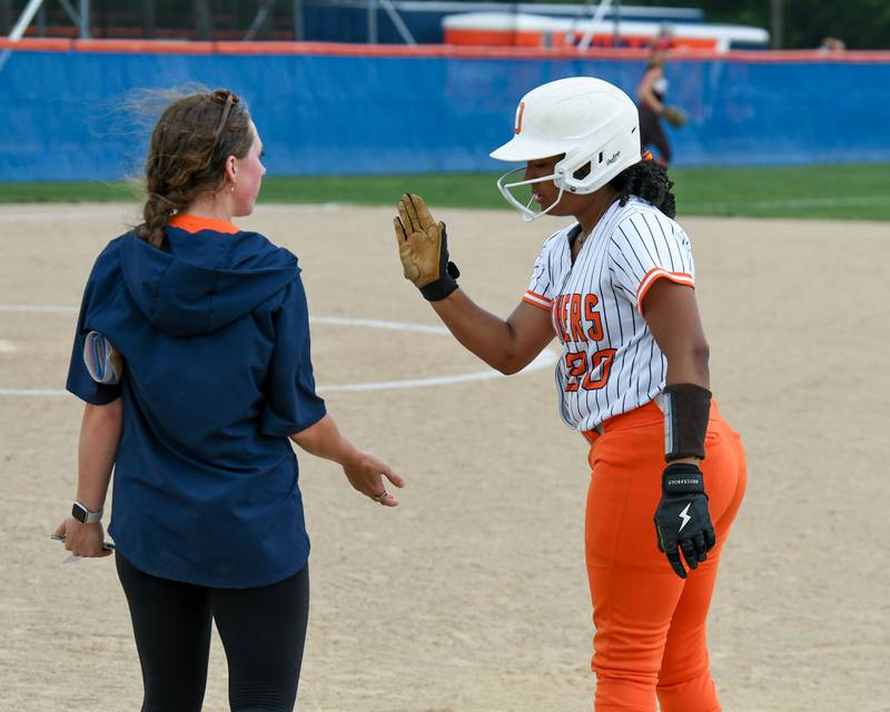 Oswego's Jaelynn Anthony (20) gets congratulated by her coach after getting a base hit on Tuesday June 3, 2025, during the sectional semifinal game held at Oswego High School.