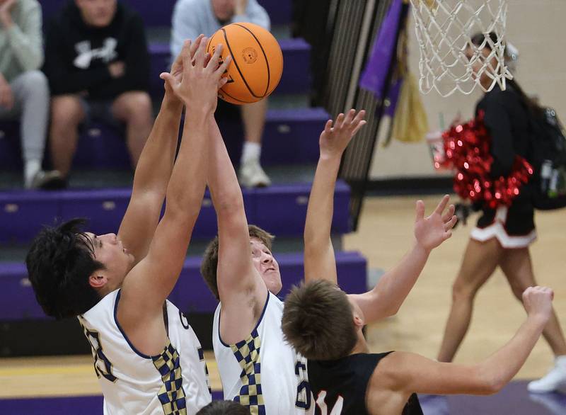 Marquette's Slayden Cassel and teammate Caden Durdan grab a rebound over Earlville's Dairk Farley during the Huskers Hardwood Tip-Off Tournament on Tuesday, Nov. 25, 2025 in Serena.