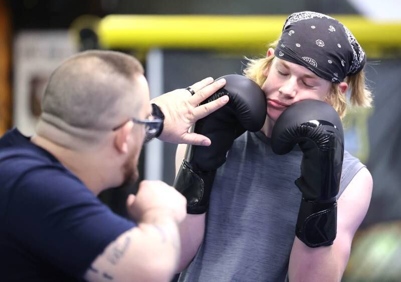 Joe Judkins, (left) head coach at Evolve MMA and Powerlifting, shows some moves to Chase Trautvetter, 16, from Sycamore during a class Thursday, Nov. 9, 2023, at the facility in DeKalb.