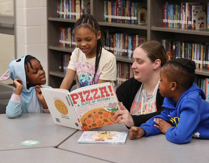 Mitchell Elementary School first grade teacher Cassandra Sprankle reads a book to some of her students Thursday, March 19, 2026, in the library at the school in DeKalb.