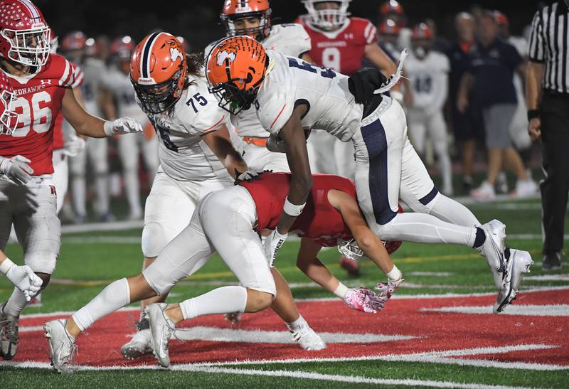 Naperville Central’s Aidan Sheehy upends Naperville North’s Luke Williams in a high school football game at North Central College in Naperville on Friday, September 29, 2023.