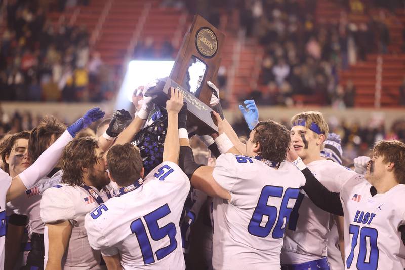 Lincoln-Way East holds up the runner-up trophy after the Griffins 26-15 loss against Loyola in the Class 8A championship on Saturday, Nov. 25, 2023 at Hancock Stadium in Normal.