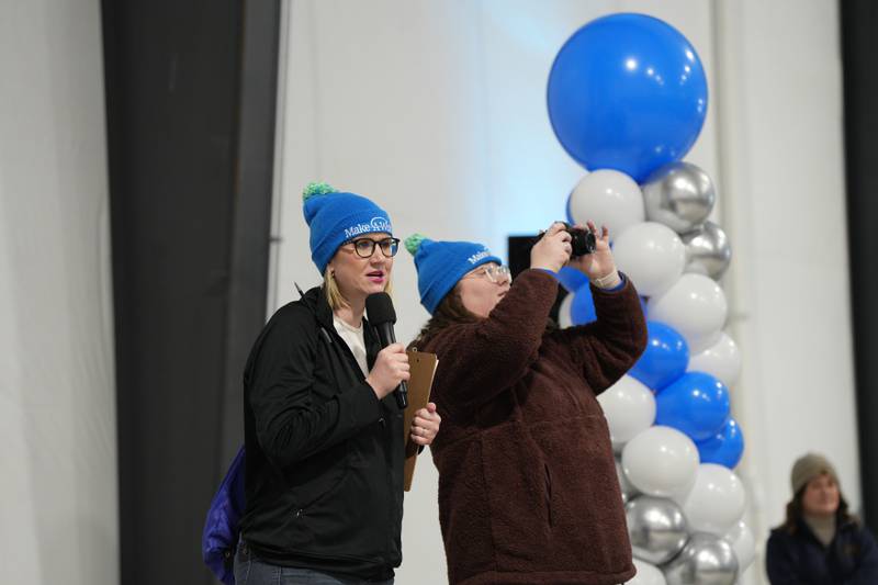 Ashley White of Chicago (left) and Sloan McHugh (right) of Chicago lead a group photo of event attendees at the 2025 Penguin Plunge Saturday, Jan. 25, 2025 at Skydive Chicago in Ottawa.