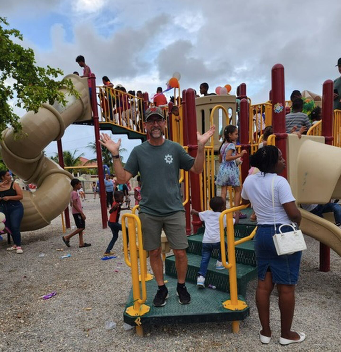 Scott Sleezer, Yorkville's superintendent of parks, celebrates as a rush of kids explore Emily Sleezer Park in Cabrera, Dominican Republic, for the very first time. Sleezer helped install the playground with the non-profit, Kids Around the World, who believes by installing a playground they can help inspire development in underprivileged communities around the world.