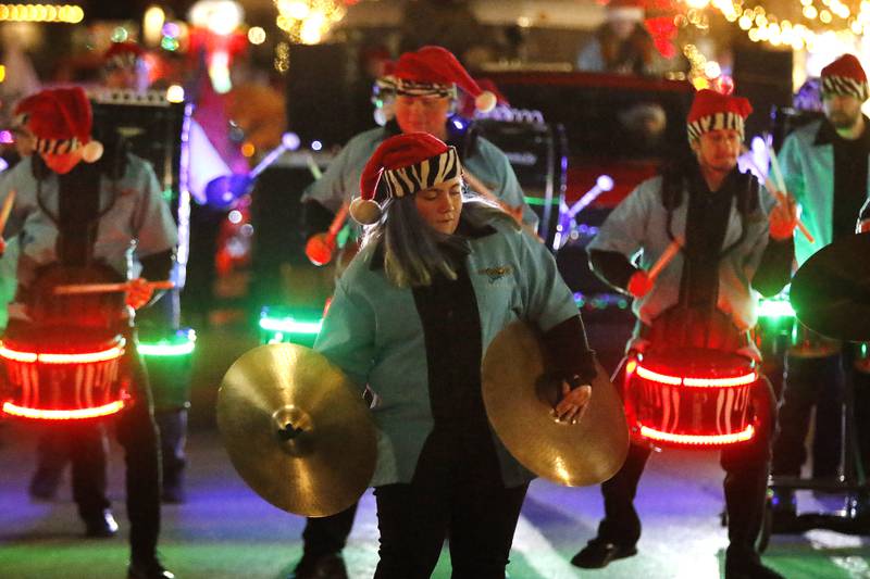 Members of the Crystal Lake Strikers Drumline entertain as they pass by during the annual Festival of Lights Parade on Friday, Nov. 26, 2021, in downtown Crystal Lake.