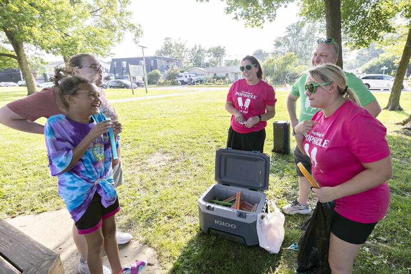 Iris Pittman, 9, and mom Emily chat with local school principals Kelli Full, Joey Sagel and Lindsay Mitchell Tuesday, August 5, 2025, at National Night Out. The principals were handing out the cool treats to remind students that “anything they set their minds to this year they can accomplish,”  said Full, the assistant Jefferson principal.