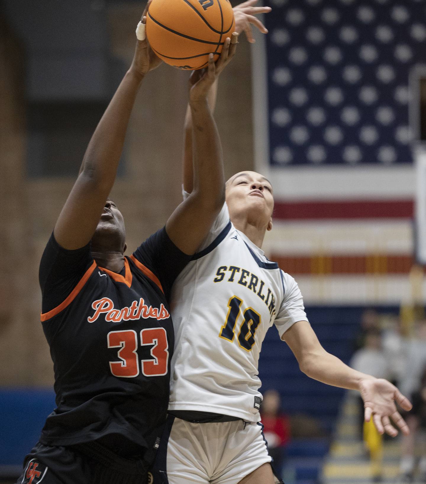 Sterling’s Nia Harris and United Township’s Lynelle Awou fight for a rebound Thursday, Dec. 18, 2025.
