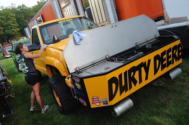 Maren Atherton of Mendota shines up the Beetz Brothers' 6200 Super Stock truck before the tractor pull competition during the Kendall County Fair in Yorkville on Friday, Aug. 2, 2024.