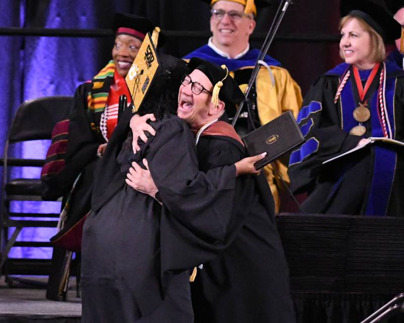 A Northern Illinois University graduate gets a hug after receiving her diploma on Saturday, May 10, 2025, during the Class of 2025 Commencement ceremony held at the Convocation Center in DeKalb.