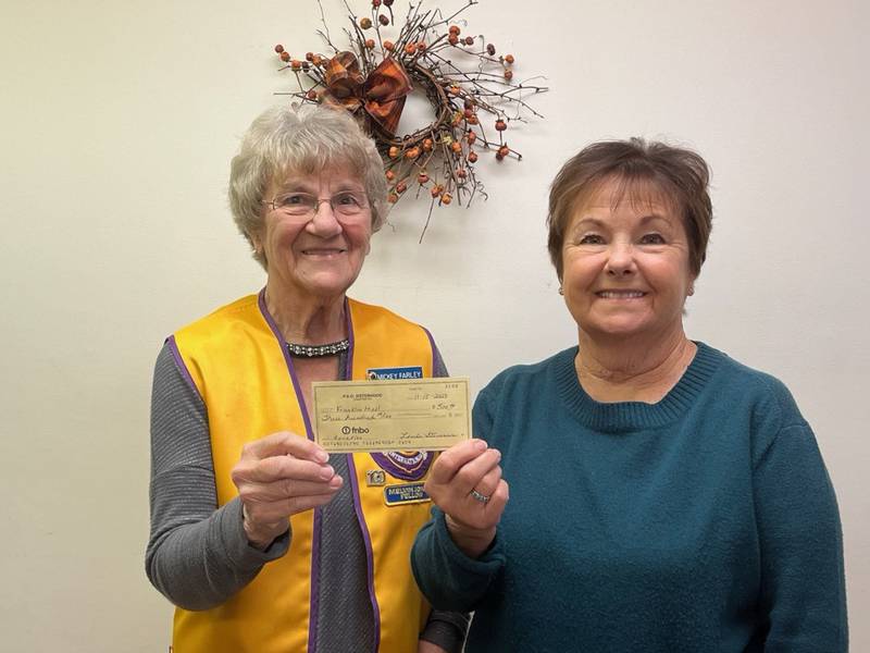 Sandwich Lions Club member Mickey Farley, left, accepts a check from Sandwich P.E.O. member Linda Benson.