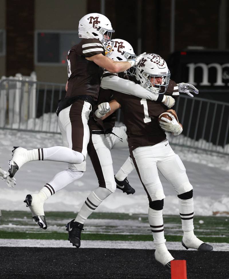 Mount Carmel's Gavin Conjar (right) celebrates with teammates after scoring on a blocked Oswego punt Wednesday, Dec. 3, 2025, in the IHSA Class 8A state chamionship game in Huskie Stadium at Northern Illinois University in DeKalb.