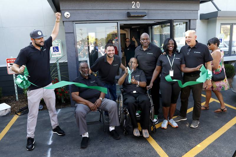 Owners of the Vertical Dispensary celebrate after cutting the ribbon during their  grand opening on Saturday, Sept. 30, 2023. The event featured former Bears quarterback Jim McMahon. McMahon is part of a group of former NFL players that launched the cannabis line, Revenant.