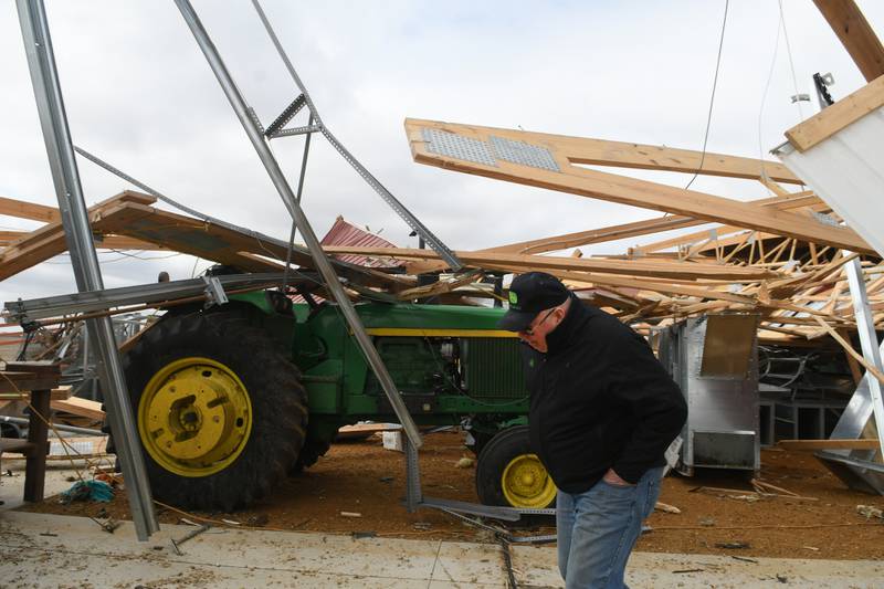Jim Ludwig of Lanark walks by one of the tractors as it sits in one of his large machine shed after it was leveled during Friday's storm along Illinois 64 about 5 miles east of Lanark.