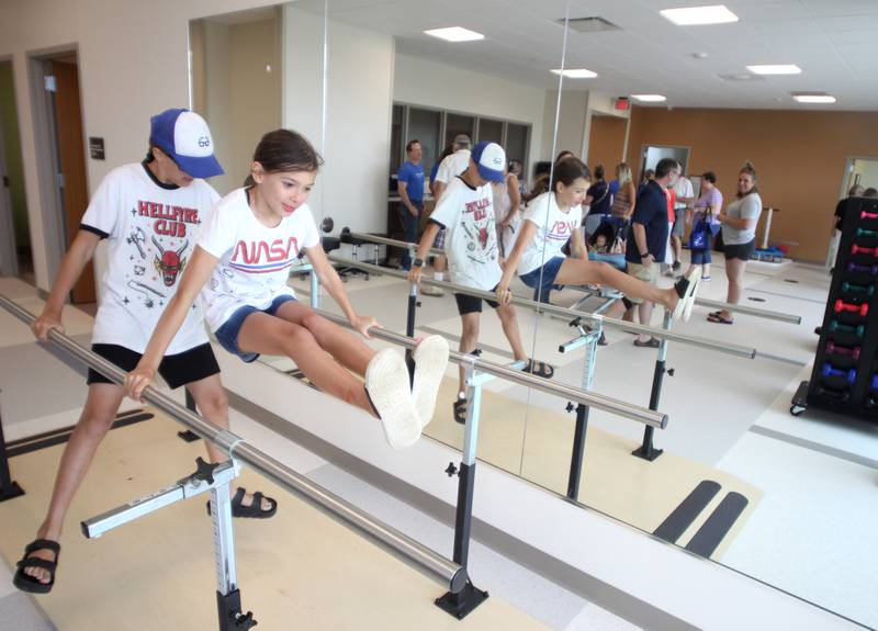 Riley Bixby, 10, of Cary tests out the equipment in the physical therapy gym during a public open house for the new Mercyhealth hospital in Crystal Lake on Saturday. Behind Bixby is Ophelia Huppert, 10, of Cary.