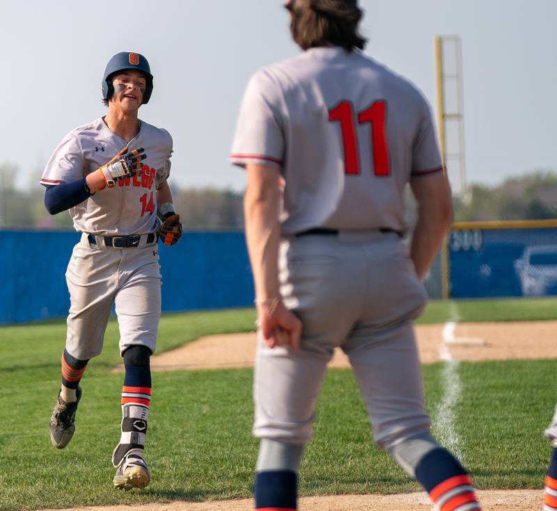 Oswego’s Trey Hernandez (14) heads for home after homering against Oswego East during a baseball game at Oswego East High School on Tuesday, May 10, 2022.