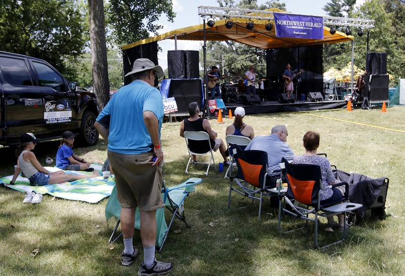 People listen to the music of Johnny Russler & The Beach Bum Band from the shade during Lakeside Festival on Thursday, July 3, 2025, on the grounds of the historic Dole Mansion in Crystal Lake,