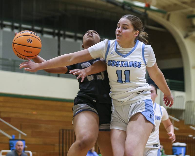 Oswego East's Inspire Fisher (23) is fouled by Downers Grove South's Olivia Lafin (11) during their York Thanksgiving Tournament matchup between Oswego East at Downers Grove South Friday, Nov 20, 2025 in Elmhurst.