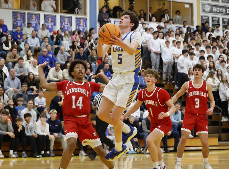 Lyons Township's Owen Carroll (5) puts up a shot during a varsity basketball game between Hinsdale Central and Lyons Township high schools on Friday, Dec. 12, 2025 in La Grange.