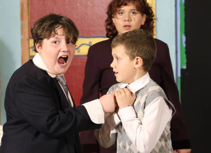 Duilio Alvarado as Drake Haney and Maddux Bell as Mr. Bloom, acts out a scene while Allison Anderson as Elaine Foxglove watches from behind during a rehearsal of “The Magic of Christmas” the Children’s Christmas Musical on Tuesday, Nov. 11, 2025 at the Prairie Art’s Center in Princeton.