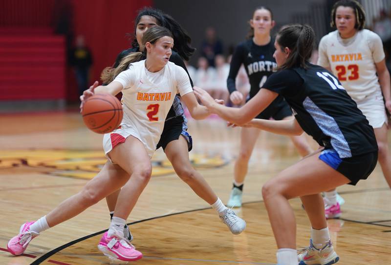 Batavia's Brooke Carlson (2) drives to the basket against St. Charles North's Riley Barber (12) during a basketball game at Batavia High School on Tuesday, Dec 5, 2023.