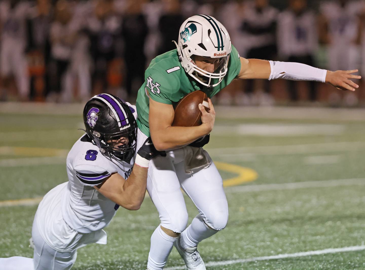 Downers Grove North's Joe Edwards (8) wraps up York's Bruno Massel (1) during the varsity football game between Downers Grove North and York on Friday, Oct. 4, 2024 in Elmhurst.