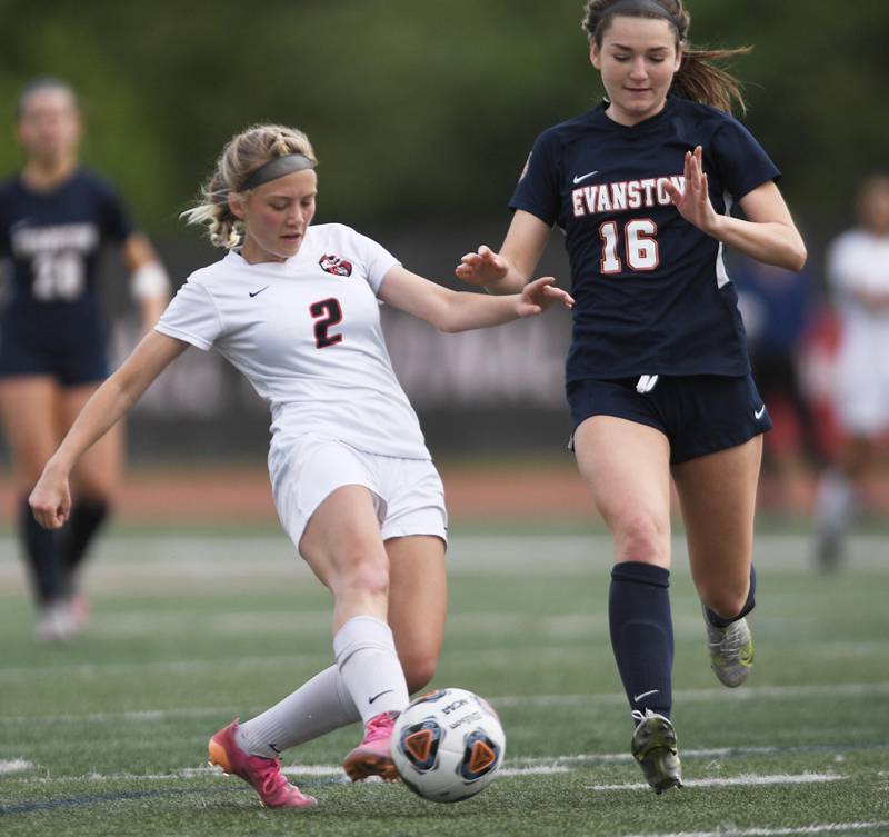 Lincoln-Way Central’s Emma Olson kicks past Evanston’s Carly Menocal in the Class 3A IHSA state girls soccer third-place game in Naperville on Saturday, June 4, 2022.