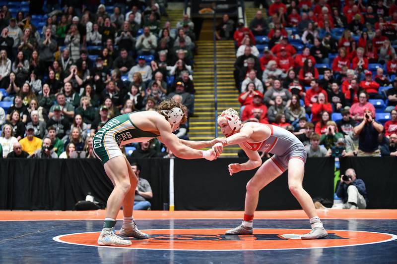 Surrounded by their respective fan sections, Brody Widlowski of Coal City, left, and Brody Matthews of Vandalia wrestle in the 138-pound match during the IHSA Dual Team State Finals in Bloomington on Saturday, March 1.