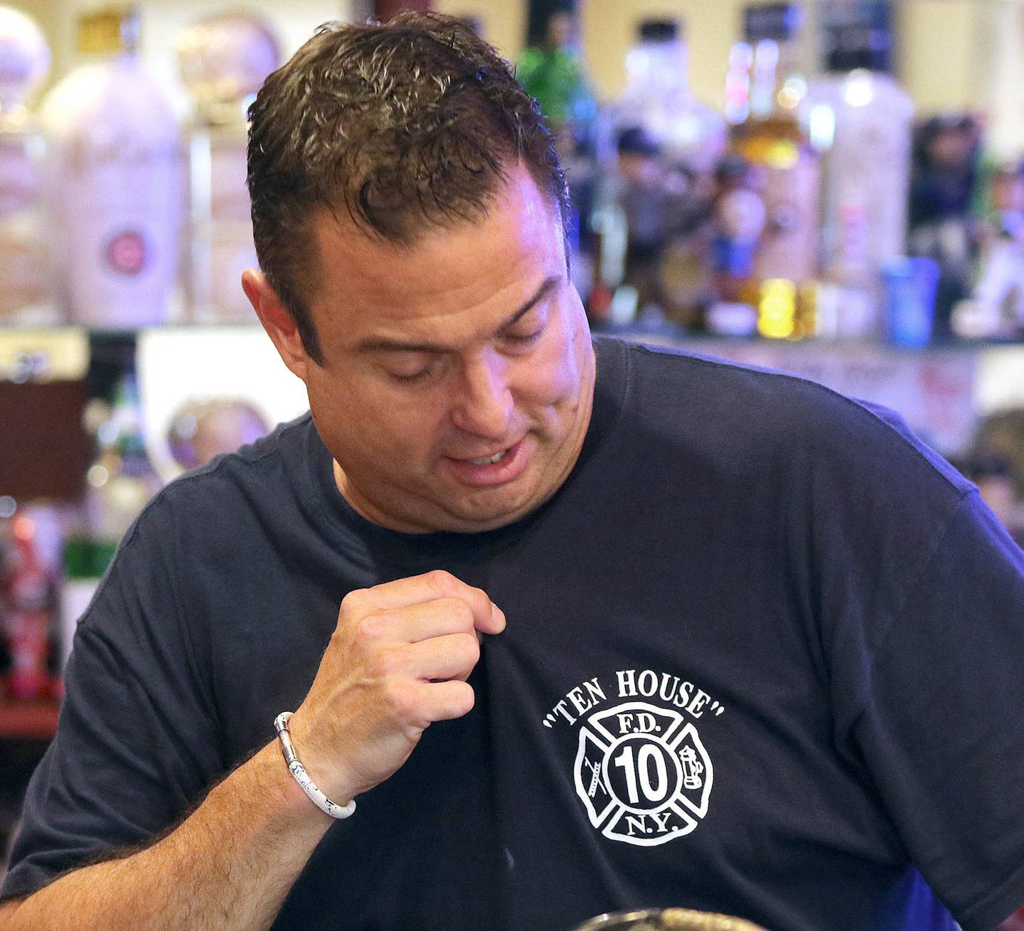 DeKalb firefighter/paramedic Pat Eriksen, wears a shirt Monday, Aug. 30, 2021, in his Sugar Grove home, from a fire house near Ground Zero he visited on a trip to New York City. One of Eriksen's cousins was John Joseph Florio, a New York City firefighter from Engine Company 214 out of Brooklyn, who was killed while responding to the Twin Towers during the Sept. 11, 2001 terrorist attacks. This year marks the 20th anniversary of the tragedy.