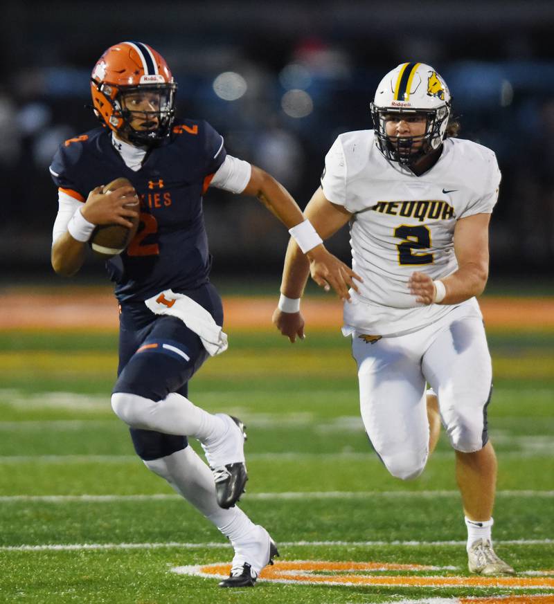 Joe Lewnard/jlewnard@dailyherald.com
Naperville North quarterback Jacob Bell carries the ball while being pursued by Neuqua Valley’s Nick Williamson during Friday’s game in Naperville.