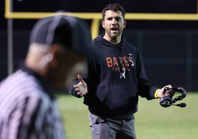 DeKalb football head coach Derek Schneeman talks to an official during their game Friday, Oct. 11, 2024, at Waubonsie Valley High School in Aurora.