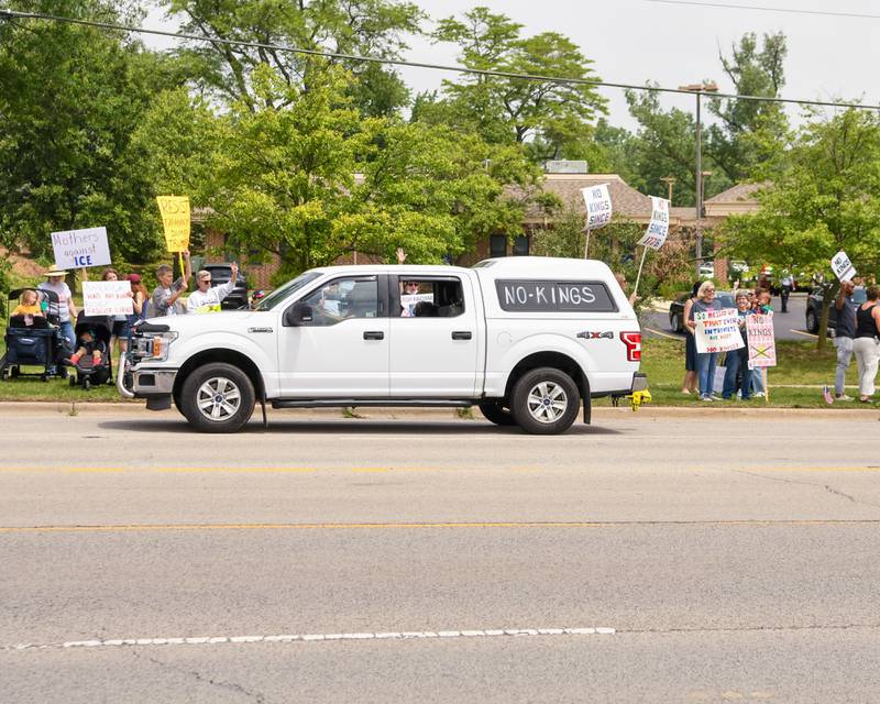 On Saturday June 14, 2025, a vehicle drives down Ogden Ave. in Lisle near the tesla dealership with the words “No King” written on it as it passes the No King rally.