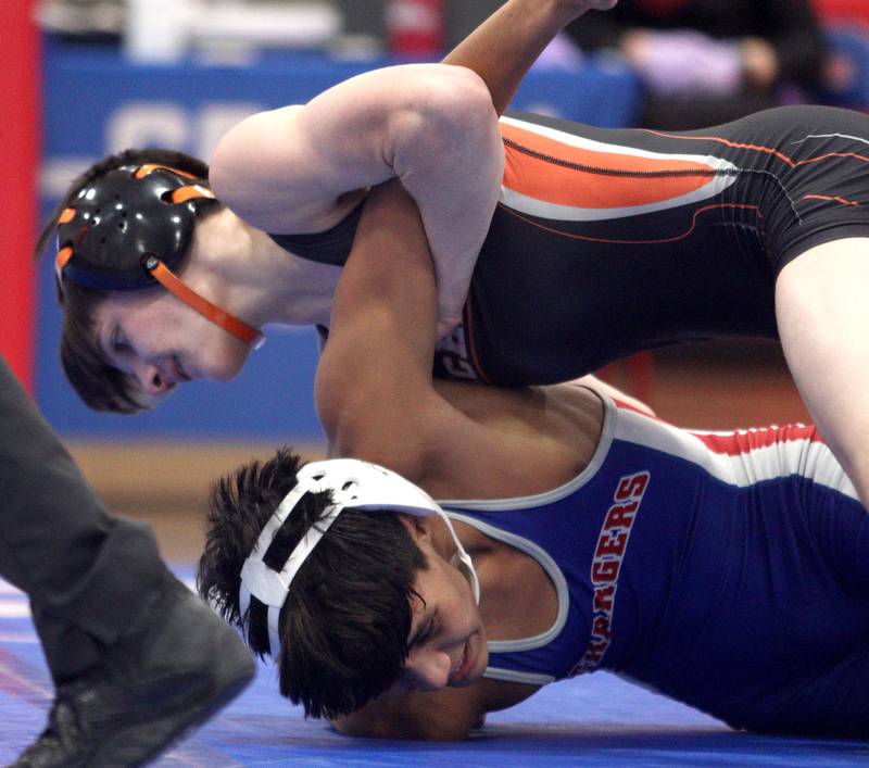 McHenry’s Ryan Hanson, top, battles Dundee-Crown’s Christian Gerardo in a 120-pound bout in varsity wrestling at Carpentersville Thursday night.