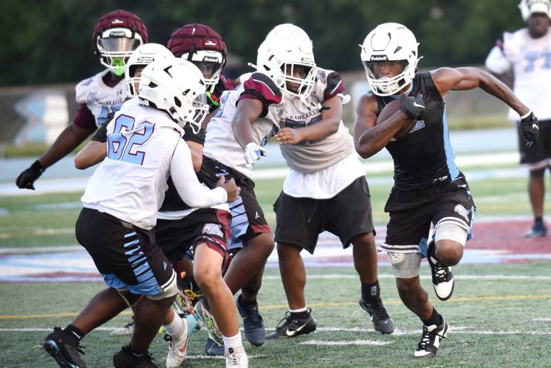 Kankakee's Zayden Henley, right, runs past the defense during practice Monday, Aug. 11, 2025.