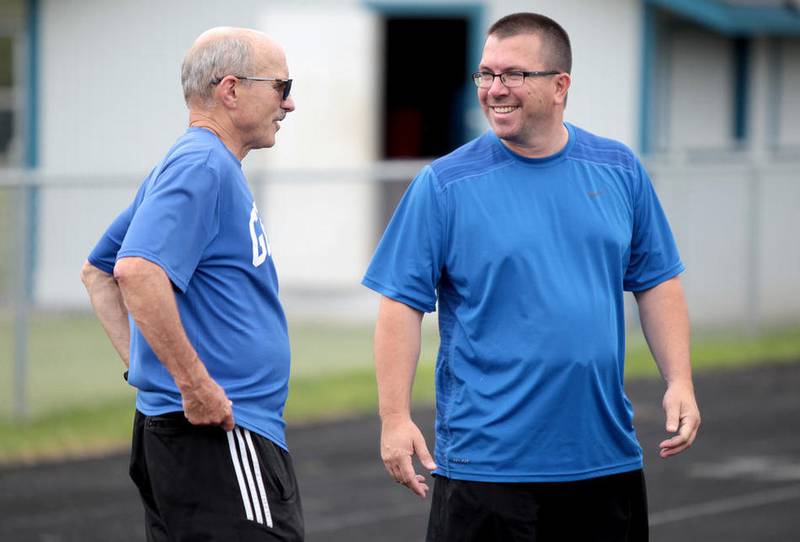 Geneva High School athletic director Dave Carli (right) chats with his predecessor Jim Kafer on July 18 during a football summer practice at the school. Carli took over at AD on July 1 after Kafer retired on June 30.