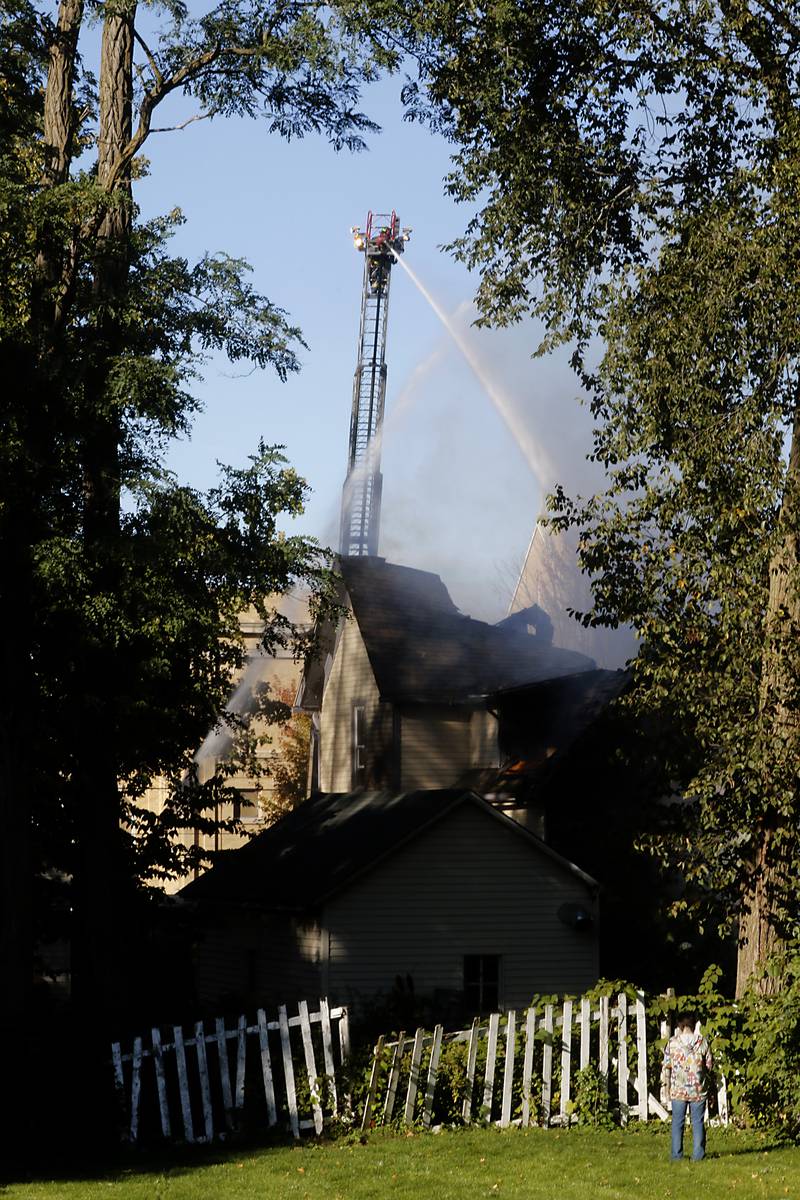 Firefighters battle a house fire in the 300 block of Lincoln Avenue in Woodstock Monday, Oct. 9, 2023, after an explosion following suspected gas leak in the area.