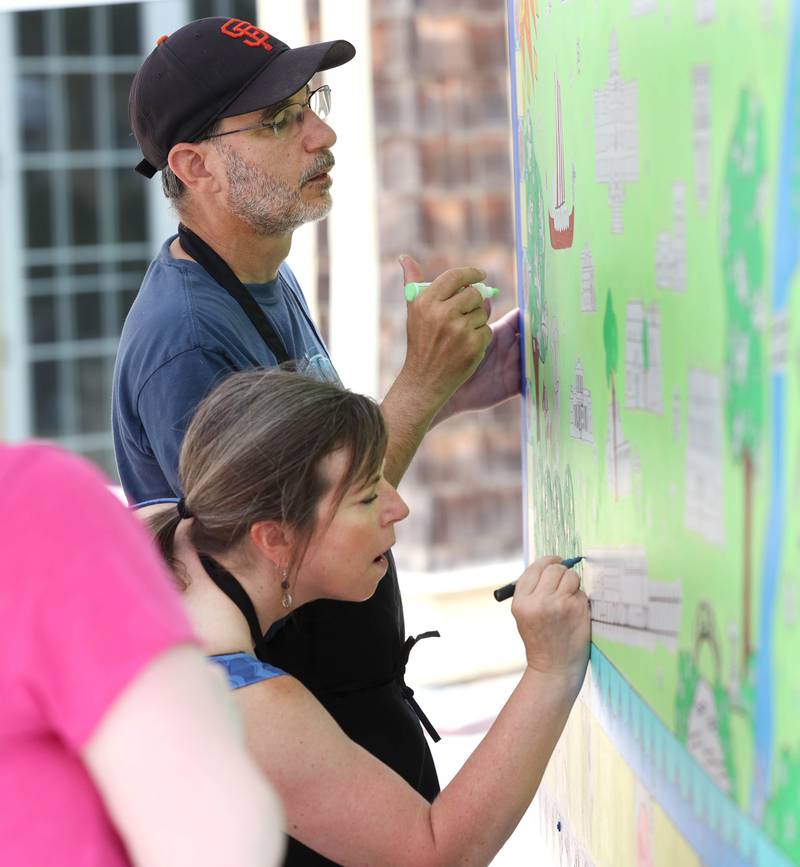 Sandy Kresler and Mike Litwin, both from Geneva, work on the Geneva Chamber of Commerce’s paint-by-number community art project Saturday, July 26, 2025, during at the Geneva Arts Fair on Third Street in Geneva.