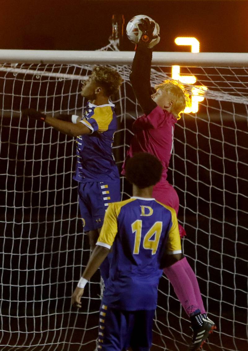 Prairie Ridge's Christopher Zinevich grabs a shot on goal between tow Chicago De La Salle players during an IHSA Class 2A state semifinal soccer match on Friday, Nov. 8, 2024, at Hoffman Estates High School.