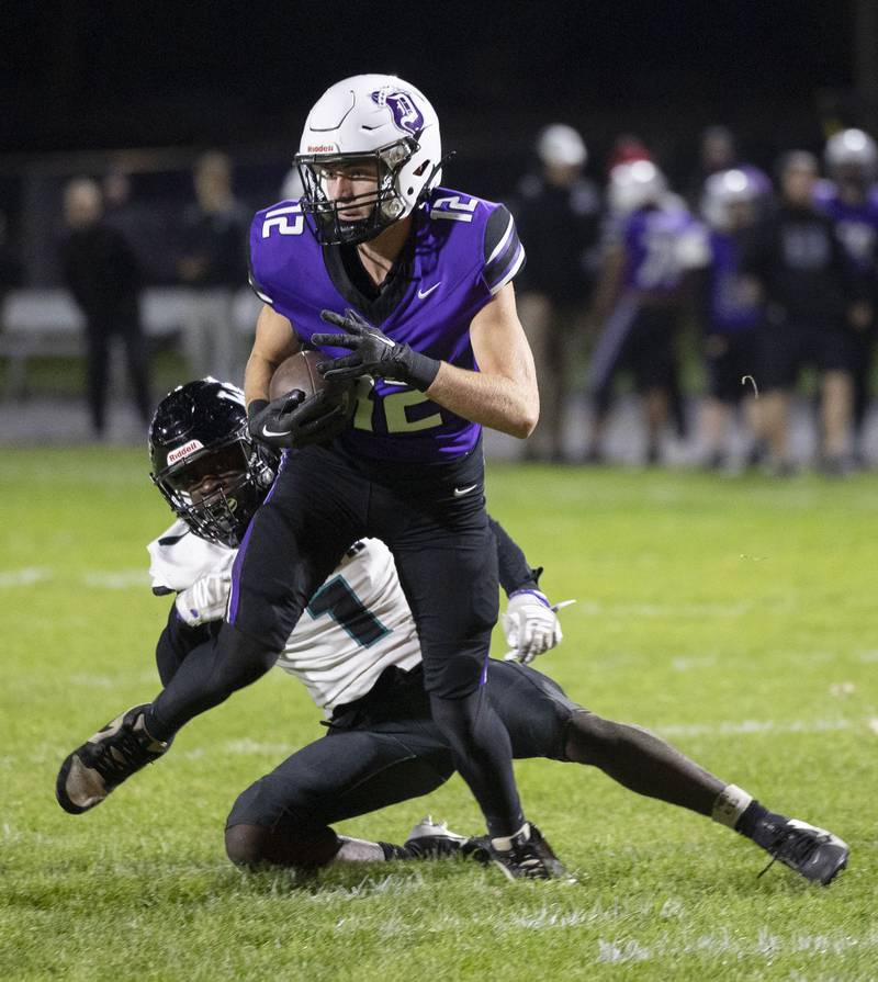 Dixon’s Jackson Koehler breaks a tackle against Woodstock North’s JR Fadahunsi Friday, Oct. 31, 2025, in the Class 4A football first round playoffs.