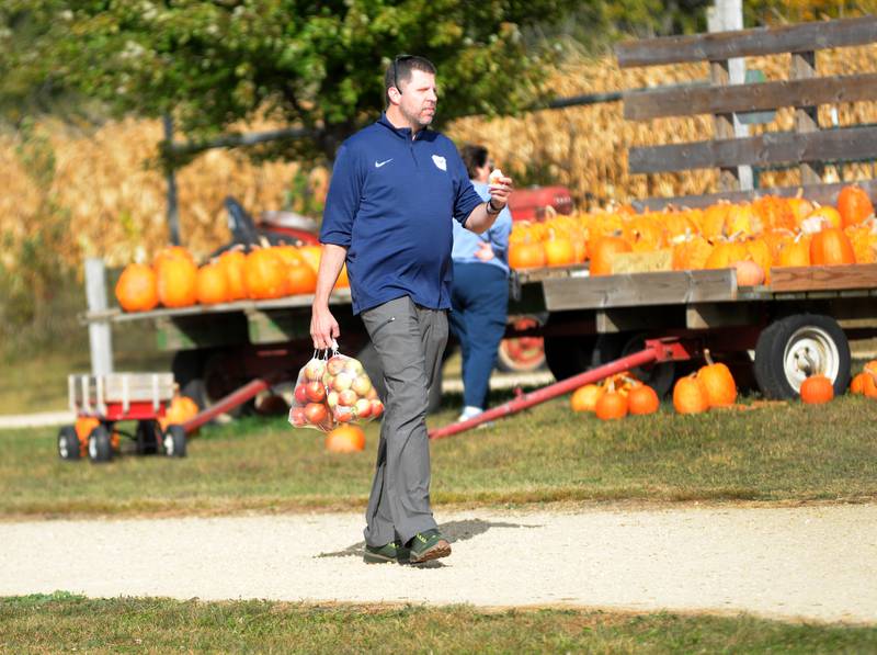 A visitor to BerryView Orchard carries a bag of apples from the store during the Ogle County Farm Stroll on Sunday, Oct. 12, 2025.
