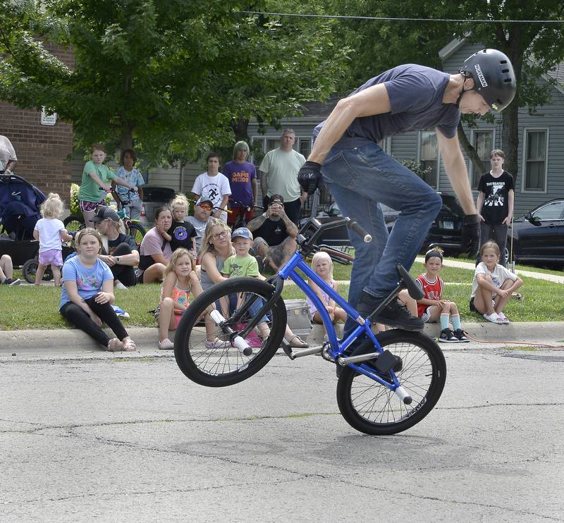 BMX Champion Matt Wilhelm performs riding tricks on Washington Street in Ottawa before a large crowd Thursday, July 28, 2022, during a show for the Reddick Library.