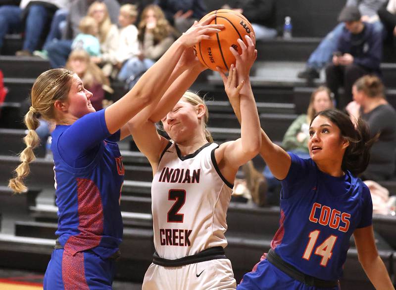 Indian Creek's Gretta Oziah tries to grab a rebound between Genoa-Kingston's Arielle Rich (left) and Alexa Ayala Monday, Dec. 8, 2025, during their game at Indian Creek High School in Shabbona.