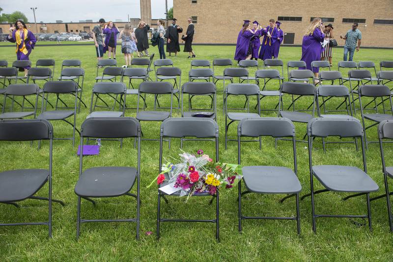 Flowers sit on a chair in memory of classmate Riley Riggen during Dixon High School’s graduation.
