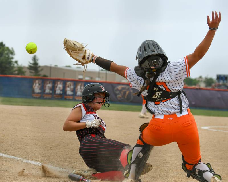 Oswego's catcher Kiyah Chavez, right, reaches for the ball as Yorkville's Rilee Petrusa (14) slides into home safely for a run during the sectional semifinal game on Tuesday June 3, 2025, held at Oswego High School.